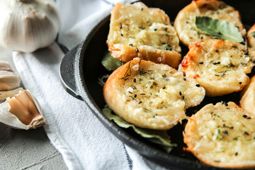 Pan with tasty garlic bread on table, closeup