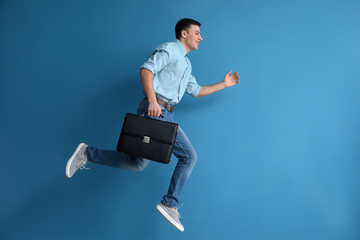 Running man with briefcase on color background