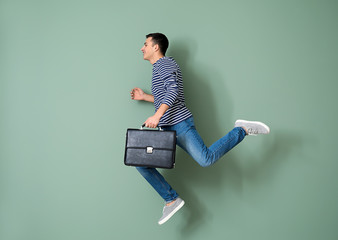 Running man with briefcase on color background