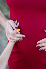 A close up of a mom and son holding the woman's pregnant tummy
