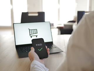 Online Shopping am Laptop Bezahlung mit Handy