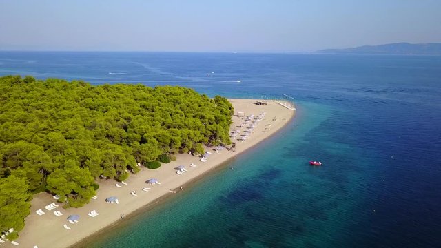 Aerial bird's eye view video taken by drone of exotic seascape and sandy beach with turquoise clear waters and pine trees, Gregolimano, North Evoia island, Greece