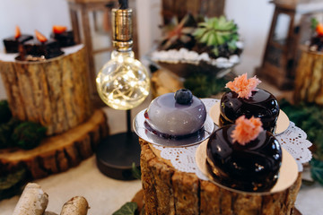 Delicious desserts and cakes with blueberries and strawberries on a beautifully decorated table with wooden elements