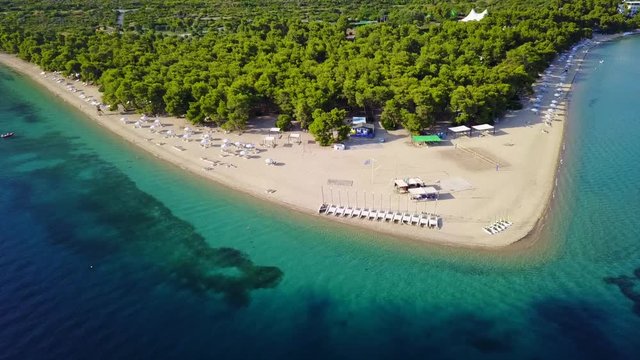 Aerial bird's eye view video taken by drone of exotic seascape and sandy beach with turquoise clear waters and pine trees, Gregolimano, North Evoia island, Greece