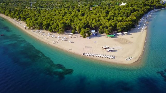 Aerial bird's eye view video taken by drone of exotic seascape and sandy beach with turquoise clear waters and pine trees, Gregolimano, North Evoia island, Greece
