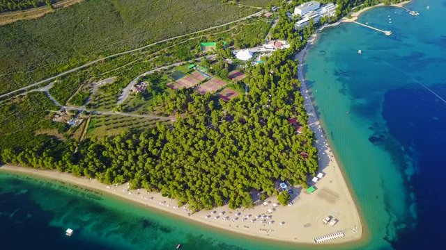 Aerial bird's eye view video taken by drone of exotic seascape and sandy beach with turquoise clear waters and pine trees, Gregolimano, North Evoia island, Greece