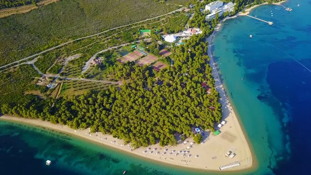 Aerial bird's eye view video taken by drone of exotic seascape and sandy beach with turquoise clear waters and pine trees, Gregolimano, North Evoia island, Greece