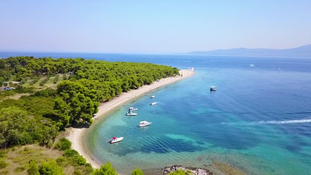 Aerial bird's eye view video taken by drone of exotic seascape and sandy beach with turquoise clear waters and pine trees, Gregolimano, North Evoia island, Greece