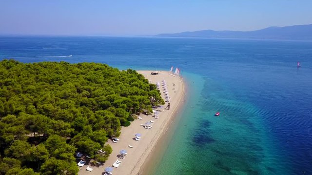 Aerial bird's eye view video taken by drone of exotic seascape and sandy beach with turquoise clear waters and pine trees, Gregolimano, North Evoia island, Greece