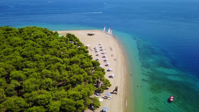 Aerial bird's eye view video taken by drone of exotic seascape and sandy beach with turquoise clear waters and pine trees, Gregolimano, North Evoia island, Greece