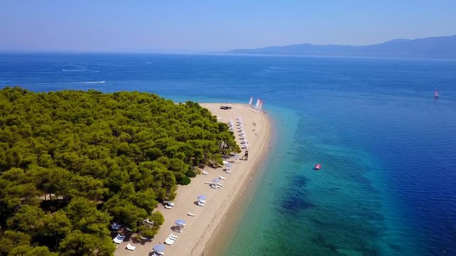 Aerial bird's eye view video taken by drone of exotic seascape and sandy beach with turquoise clear waters and pine trees, Gregolimano, North Evoia island, Greece