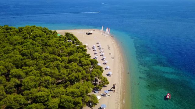 Aerial bird's eye view video taken by drone of exotic seascape and sandy beach with turquoise clear waters and pine trees, Gregolimano, North Evoia island, Greece
