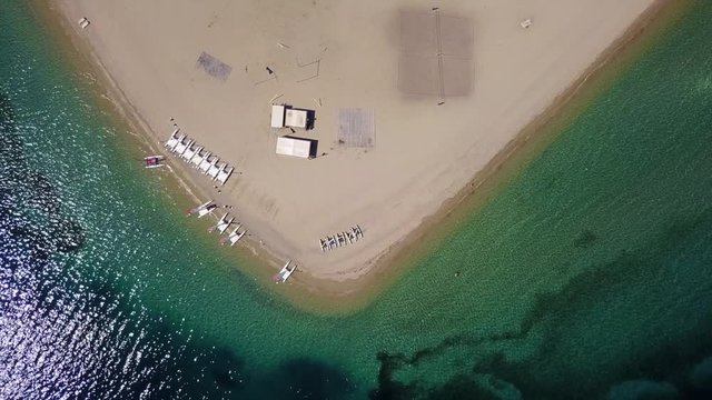 Aerial bird's eye view video taken by drone of exotic seascape and sandy beach with turquoise clear waters and pine trees, Gregolimano, North Evoia island, Greece