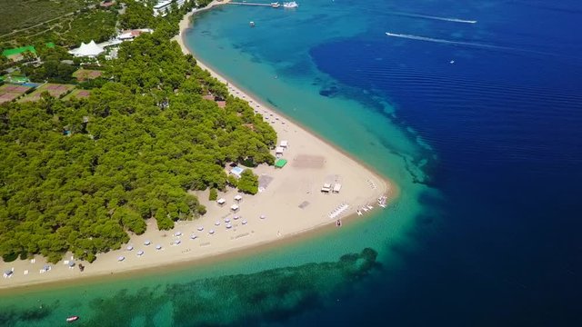 Aerial bird's eye view video taken by drone of exotic seascape and sandy beach with turquoise clear waters and pine trees, Gregolimano, North Evoia island, Greece