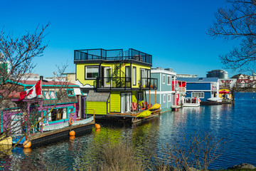 Fototapeta na wymiar Floating Home Village colorful Houseboats Water Taxi Fisherman's Wharf Reflection Inner Harbor, Victoria British Columbia Canada Pacific Northwest. Area has floating homes, piers, restaurants.