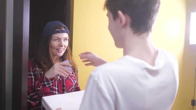 pizza delivery concept. woman delivers a box of pizza to the teenage boy . slow motion video. fast food concept fast lifestyle food delivery