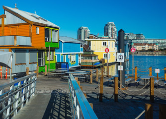 Floating Home Village colorful Houseboats Water Taxi Fisherman's Wharf Reflection Inner Harbor, Victoria British Columbia Canada Pacific Northwest. Area has floating homes, piers, restaurants.