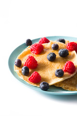 Pancakes with raspberries, blueberries and honey isolated on white background