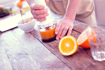 Top view of healthy man squeezing orange juice for traditional family breakfast