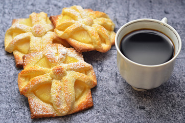 Cookies with pineapple on a gray background. Black coffee in a white cup on a gray background