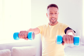 Handsome bearded man doing morning exercises at home before going to work