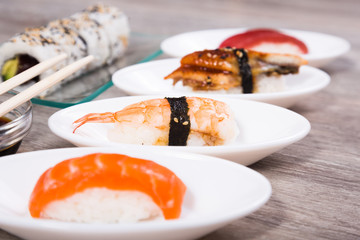 four kinds Nigirisushi on oval saucers and Uramaki