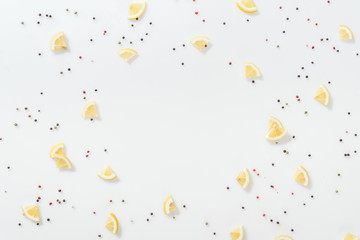 flat lay of lemon slices near red and black peppercorns isolated on white