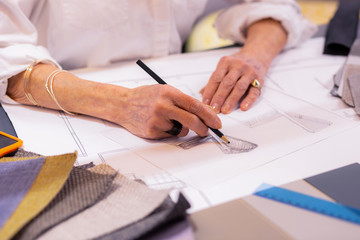 Close-up photo of elderly leading designer making drawing at desk