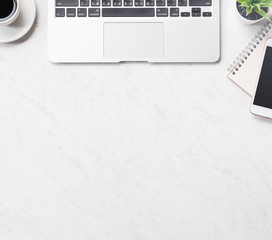 Stylized clean marble office working desk with smartphone, laptop, glasses and coffee cup,...