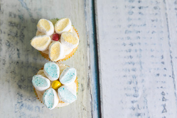 Cupcakes decorated with butter cream and marshmallow flowers