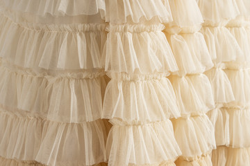 Tulle beige luxury dress with ruffles. Closeup detailed background.