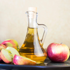 Processing of an agricultural crop of red and green apples. Home canning, healthy diet vegetarian food. Apple cider vinegar, juice, cider in a glass jar next to ripe fruit