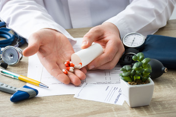 At doctors appointment physician shows patient capsules, which emptied into hand from container...