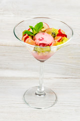 Ice cream in a glass cup with apples and kiwi