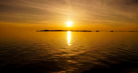 Icebergs floating in the ocean during sunset midnight sun in the Ilulissat Icefjord in Greenland.