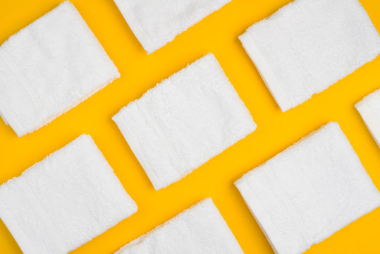 White clean soft folded towels arranged on yellow background