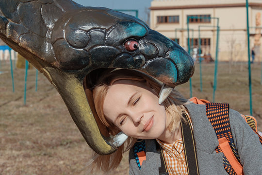 The head of a woman in the mouth of a snake.