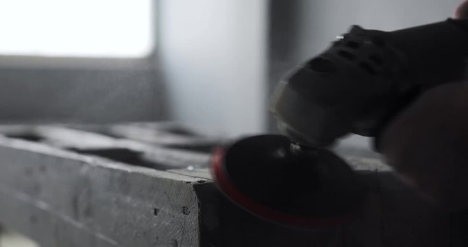 Carpenter polishing wood using electric grinder with polishing extender. close up