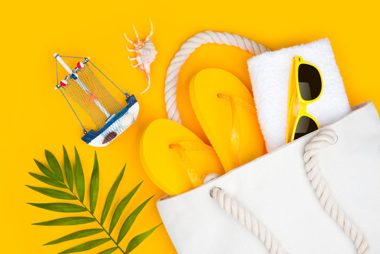 Summer travel concept. Vacation symbols and accessories on yellow background