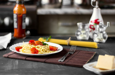 Spaghetti pasta in tomato sauce with cheese and parsley. Italian spaghetti pasta over dark stone background.