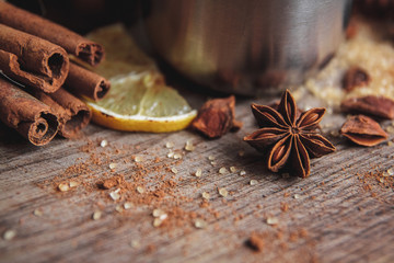 Freshly homemade mulled wine in a bowl with fragrant species, citrus fruits, lemon on a wooden rusric board. Close up.