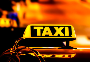 Illuminated with yellow taxi sign on a car roof