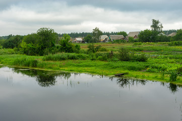 Fototapeta premium Summer gloomy landscape with Kotelva river in Kotelva village, Poltavskaya oblast, Ukraine