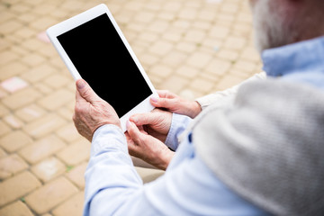 senior couple using digital tablet while sitting together