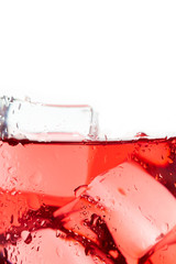 Closeup of red ice tea in glass with ice cubes. Copy space