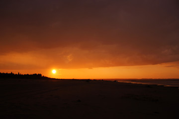 Sunset landscape, yellow golden sky, sandy beach
