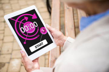 selective focus of senior woman using digital tablet with timer on screen