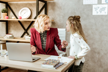 Long-haired little girl interfering her blonde mother