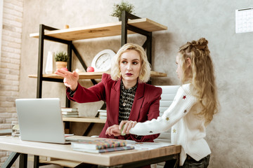 Serious short-haired mother showing her daughter place for rest