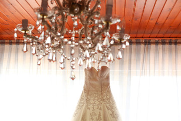 beautiful white wedding dress hanging up in a window